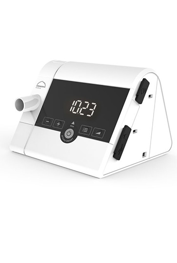 Das moderne, weiß-graue prisma SMART max CPAP-Therapiegerät von Löwenstein Medical. Das Gerät verfügt über eine dreieckige Bauform, ein großes, gut ablesbares Display mit digitaler Zeitanzeige und ist für die automatische Druckanpassung (AutoSet) bei der Schlafapnoe-Therapie konzipiert.