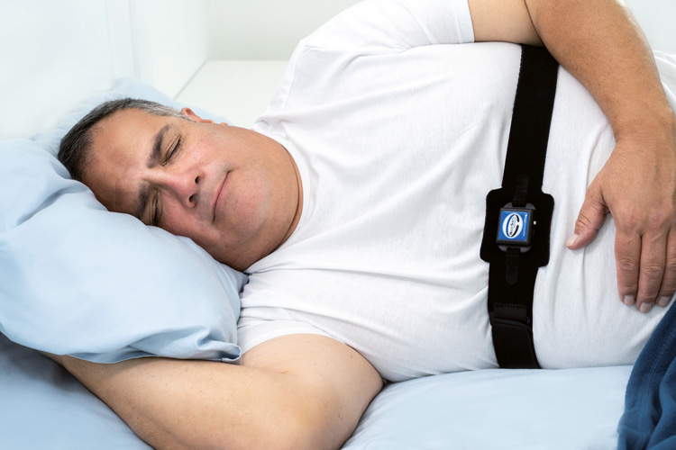 Patient schläft mit dem NightShift LE Positioner am Brustgurt von VIVISOL Heimbehandlungsgeräte Wien